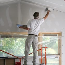 Applying mud to freshly taped sheetrock.